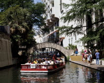 Pleasure boat passing under a bridge over Paseo del Rio beside the River Walk