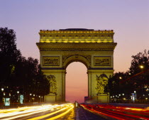 Arc de Triomphe at night with light trails from passing cars.