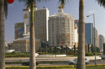 Casino Lisboa.  Exterior framed by palm tree trunks in foreground.Former portuguese territory reverted to Chinese rule in 1999