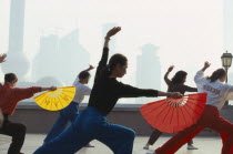 Early morning group exercise using fans on the Bund.