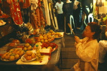 Female performer at the Chinese Opera offering joss sticks in prayer