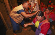 Lisu shaman anointing supplicants head at healing ceremony