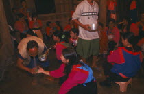 Lisu shaman spraying supplicants hand at healing ceremony