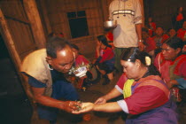 Lisu shaman spraying supplicants hand at healing ceremony