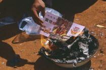 Lisu man burning imitation paper money for New Year