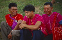 Three Karen men in red tunics and shoulder bags