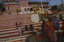 Kedar Ghat. Hindu worshippers beside the Ganges River in the early morning with steps leading up to Kedara Mandir temple