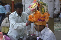 Sankat Mochan Mandir temple. A groom having his headdress / hat adjusted at his wedding outside the temple