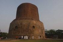 Pilgrims from Thailand walk around Dhamek Stupa led by monks