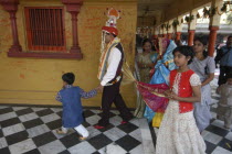 Sankat Mochan Mandir temple. A groom walks around the temple sanctuary with his bride tied to him behind