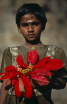 Portrait of a girl holding a large red flower