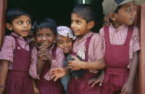 Group of young school children wearing red uniform