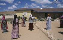 Girls playing volleyball at Fatima Bihi school wearing long skirts and head coverings.