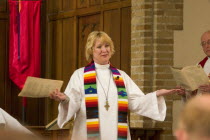 Pastor greeting the congregation while officiating at an ordination in the sanctuary of Grace University Lutheran Church.