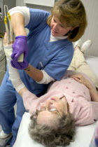 Clinic nurse recasting broken wrist of 90 year old patient