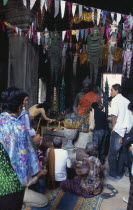 Banteay Kdei.  Cambodian visitors lighting incense at shrine with seated Buddha figure at site built as Buddhist monastic complex by Jayavarman VII in the twelth century during Chinese New YearAsian...