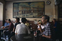 Chinatown teahouse with male locals seated in front of an old painting of ChinatownAsian Prathet Thai Raja Anachakra Thai Siam Southeast Asia Chinese Siamese