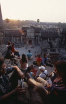 Tourists with cameras watching the sunset from the central sanctuary on the upper level. Asian Cambodian Kampuchea Religion Southeast Asia History Holidaymakers Kamphuchea Religious Tourism