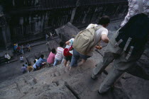 Line of tourists climbing down steep and narrow steps of tower in upper level. Asian Cambodian Kampuchea Religion Southeast Asia History Holidaymakers Kamphuchea Religious Tourism