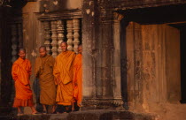 Monks standing outside the west gallery at sunsetAsian Cambodian Kampuchea Religion Southeast Asia History Kamphuchea Religious