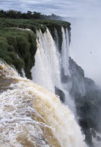 Iguazu Falls cascading over green cliffs.