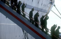 Waving soldiers returning from Angola walking down the gangway from a ship