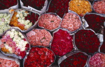 Praisani Road flower market.  Close view of tightly packed bunches of pink  red and white roses wrapped in newspaper.Asian Prathet Thai Raja Anachakra Thai Siam Southeast Asia Siamese Northern Southe...