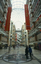 Multi level shopping centre interior with domed glass roof.