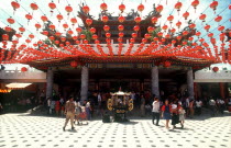 Dhean Hoy Temple  entrance with crowds of visitors and strings of coloured lanterns.