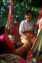 Woman selling brightly coloured fabrics and cloth.