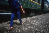 Cropped shot of a figure walking alongside green train carriage.