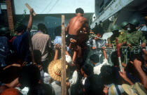 Anti Khmer Rouge demonstration outside their city headquarters.  Angry crowd at a fence armed by soldiers.