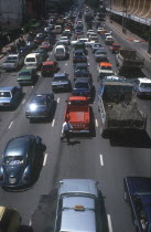 Pedestrian crossing road of six lanes of congested traffic.