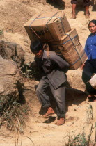 Smuggling on the Chinese border.  Heavily laden porter crossing to trade.