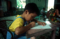 Child writing at desk in an Agent Orange orphanage.