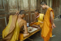 Buddhist Monks playing chess in Bangkok monastery.