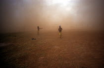 Two children emerging from the dust cloud from a M: 26 Helicopter.