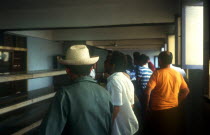 Cafe Interior with queue of men standing along empty counter