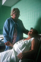 Pregnant woman in labour being attended by hospital nurse