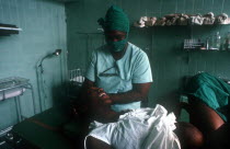 Pregant woman in advanced labour being attended by nurse in the delivery suite