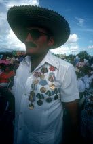 Veteran at memorial with shirt adorned with medals