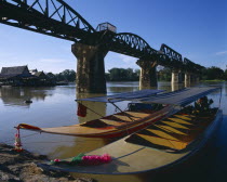 River Kwai bridge with two boats and houses behind