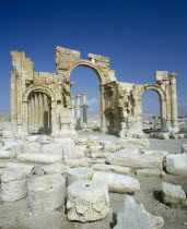 Palmyra monumental Arch remains  three arches pillars behind broken stone.