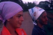 Close up of two women wearing head scarfs looking off to the right