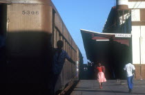 Station platform with train standing and people walking