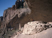 Visitor climbing ladder amongst caves.