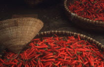 Large shallow baskets of red chilli peppers at Hanoi market.