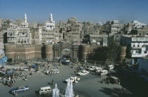 Aerial view overlooking the Old City with the city walls and entrance in the foreground with passing cars and pedestrians below