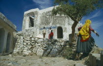 Soworthy Temple ruins children and woman wearing yellow head covering.