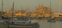 Evening view of the harbour in Palma de Mallorca with La Seo cathedral lit by the setting sun in the background.Mallorca